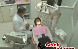 Rothaariger Zahnarzt mit schwarzen Verführerinhalten Hände von ihrem Necken
